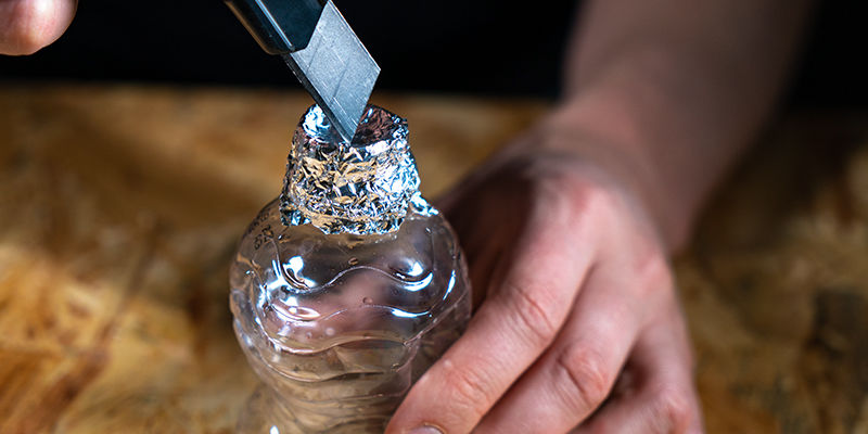 bucket bong: Verwijder De Dop Van De Eerste Fles. Wikkel Aluminiumfolie Rond De Bovenkant.