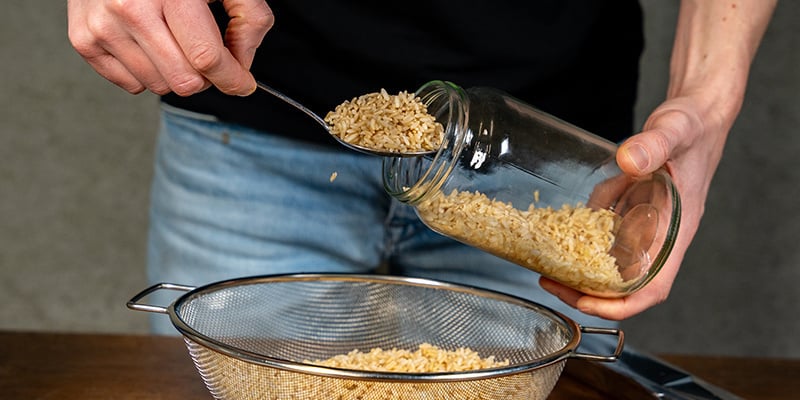 Vul glazen potten of kweekzakken met het graan van je keuze