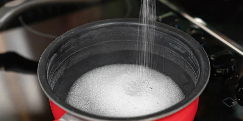 Doe het water en de suiker in een pan en verwarm op middelhoog vuur tot de suiker volledig is opgelost.