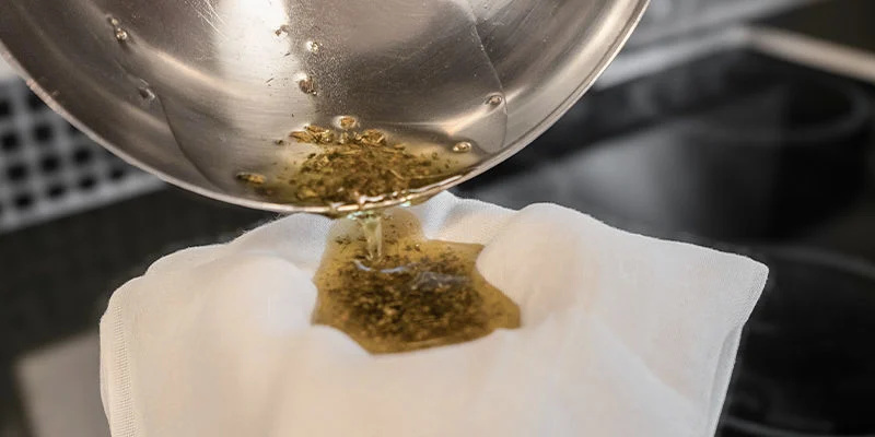 Gebruik een kaasdoek of fijne zeef om het plantmateriaal te verwijderen. 